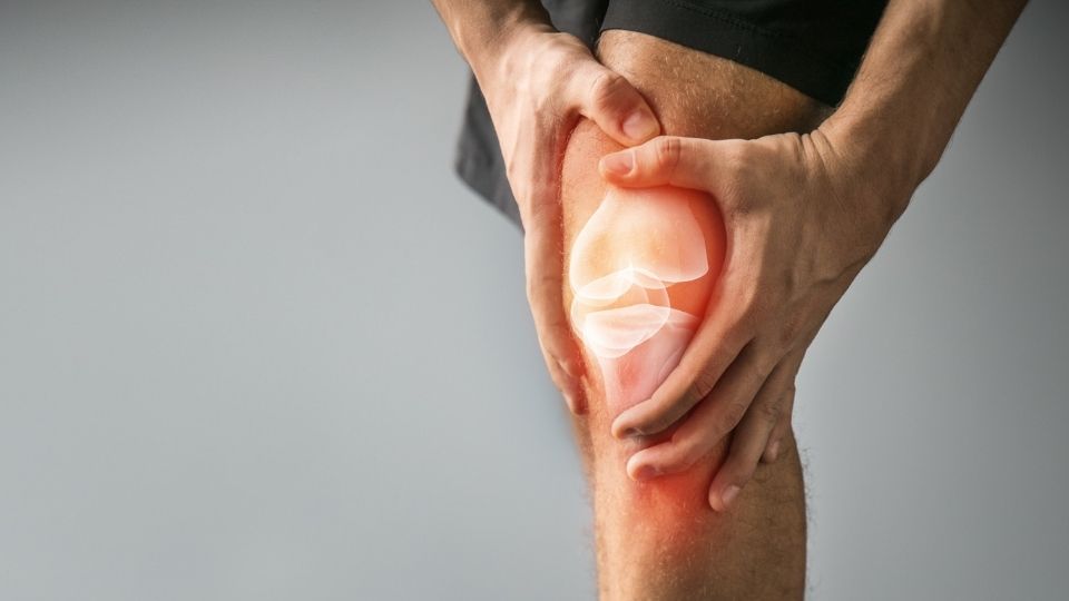 A Man Holding His Painful Knee With A Hand