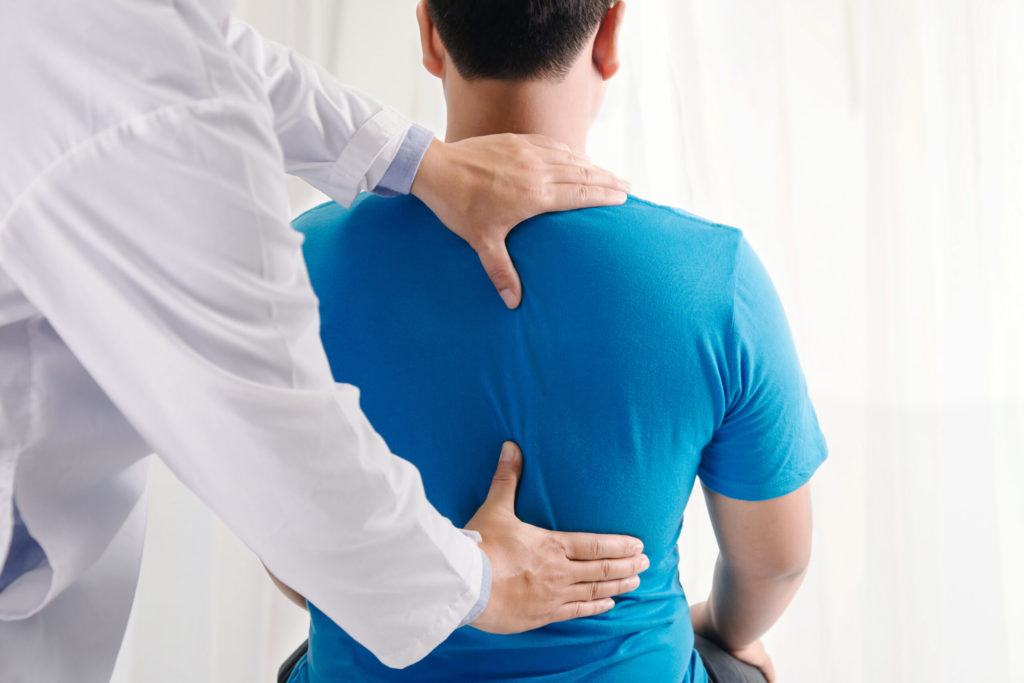Physician Examining Patients Back